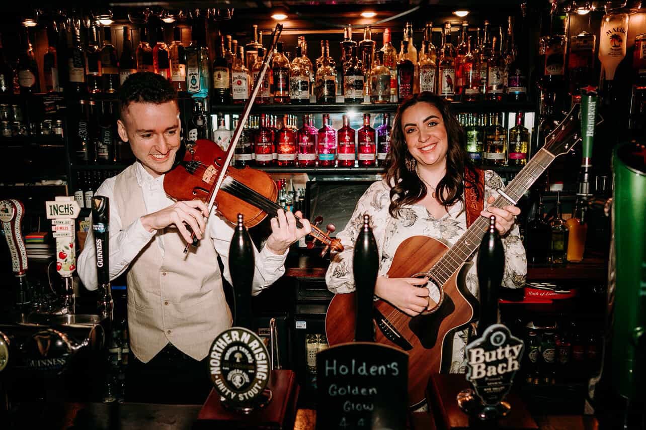 Man playing a violin and a lady playing a guitar